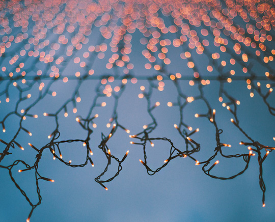 amber colored icicle lights hanging outside of a house